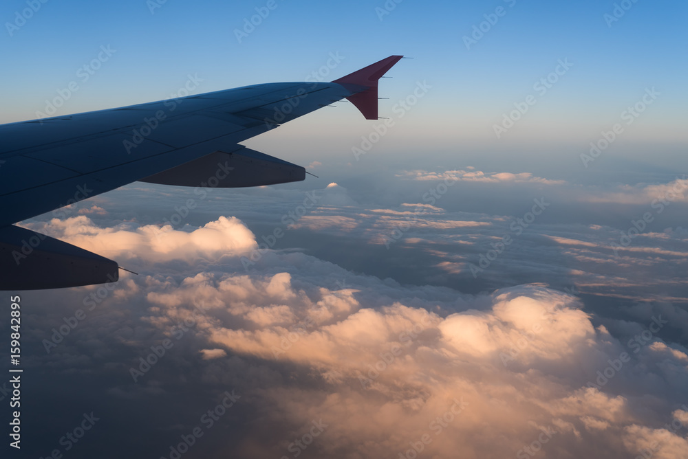 Fototapeta premium Clouds under the wing of an airplane