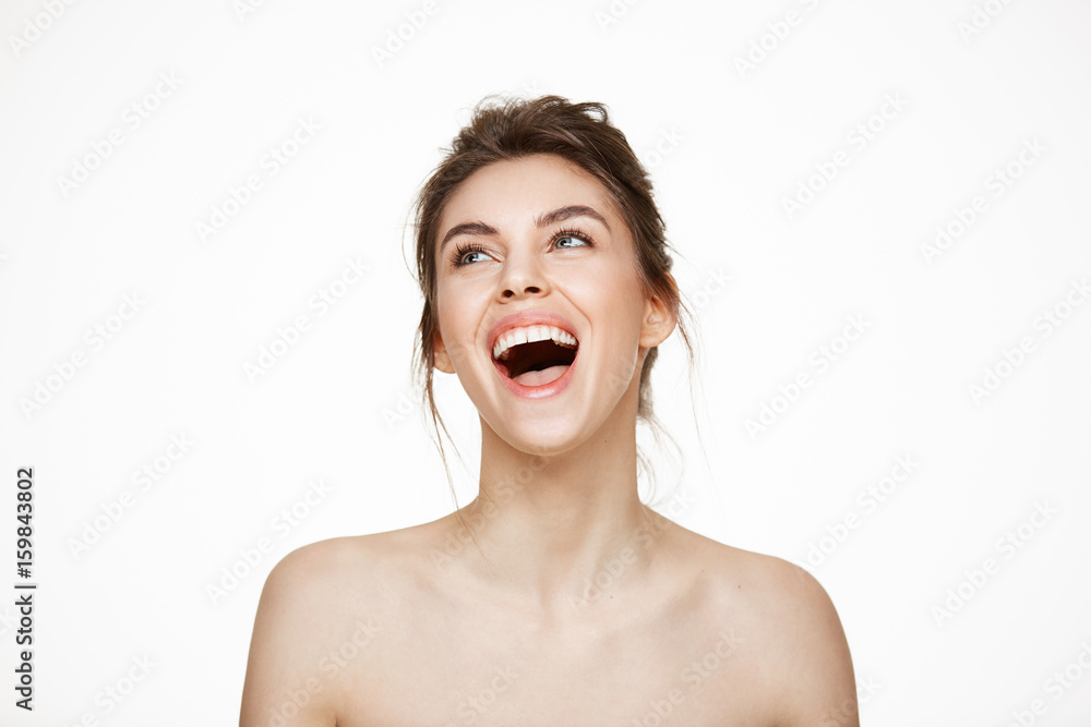 Cheerful beautiful naked girl rejoicing smiling laughing over white