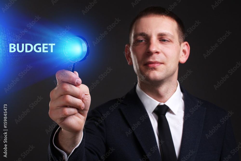 The concept of business, technology, the Internet and the network. A young entrepreneur working on a virtual screen of the future and sees the inscription: Budget The concept of business, technology, the Internet and the network. A young entrepreneur working on a virtual screen of the future and sees the inscription: Budget