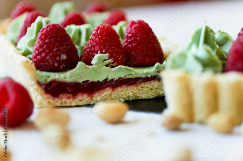 Pistachio tart. Pistachio tart on white Belgian chocolate BARRY with a layer of raspberry confit, crispy shortbread base, fading cream and juicy raspberries.A classic combination in miniature format.