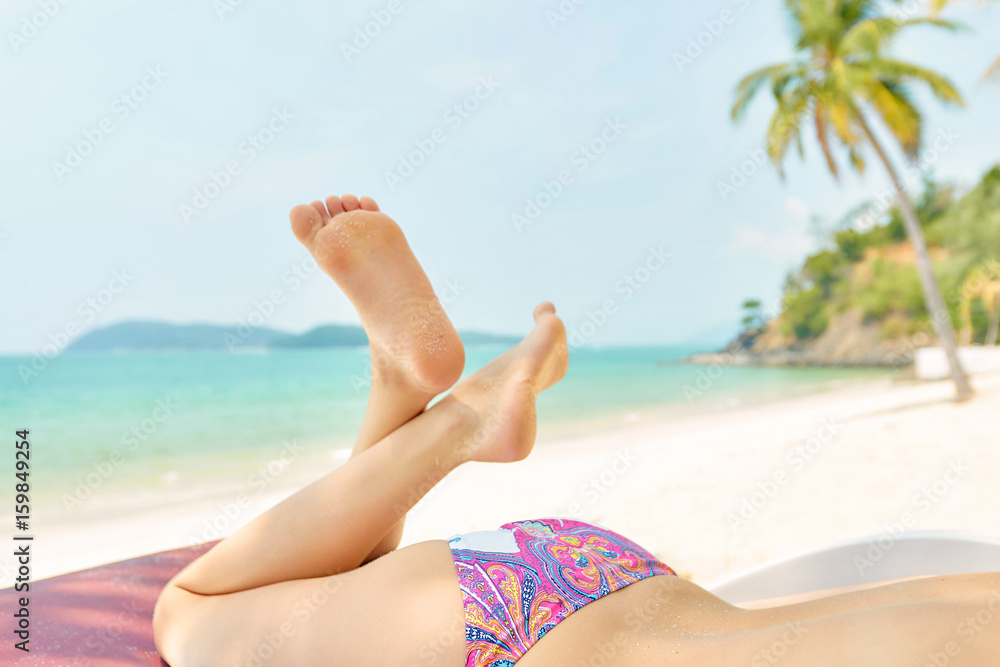 Women's beautiful body and legs on the tropical beach at Langkawi island Women's beautiful body and legs on the tropical beach at Langkawi island