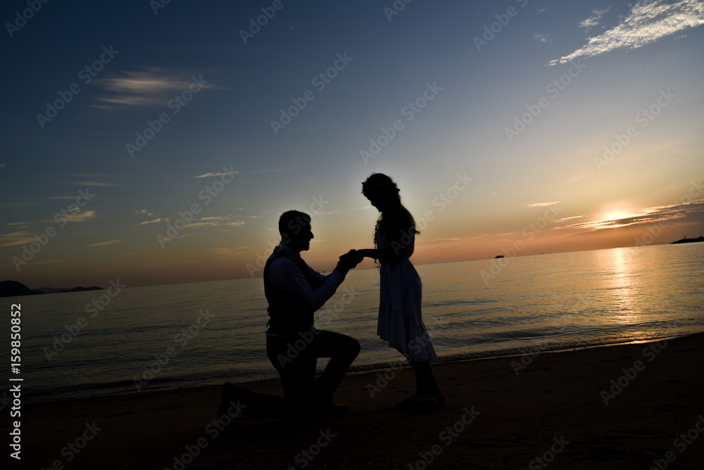 Silhouette couple on the beach with sunset