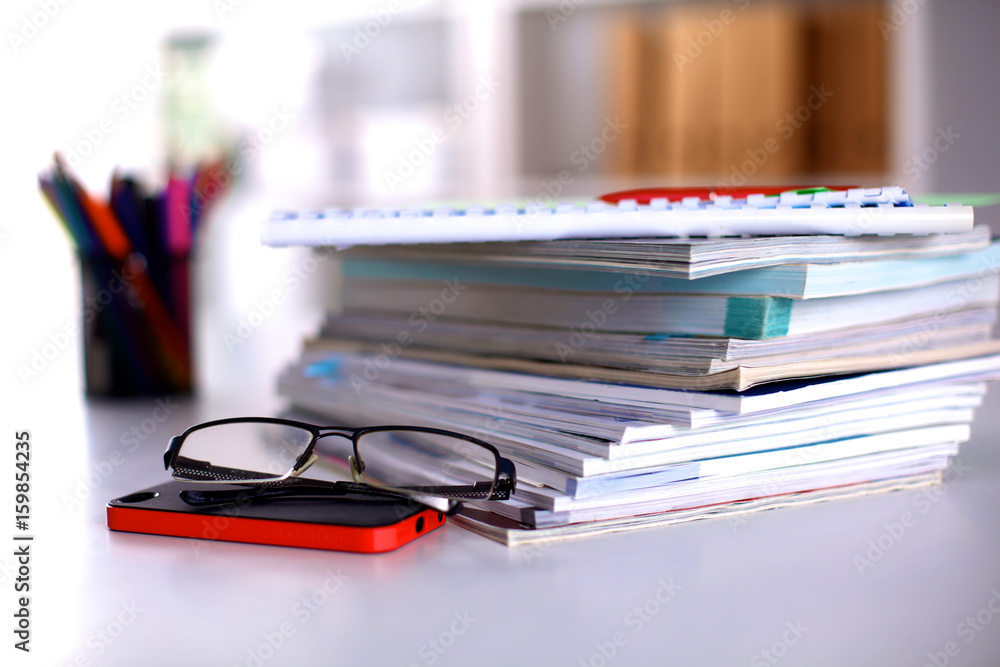 A stack of documentation is on the desktop in the office A stack of documentation is on the desktop in the office