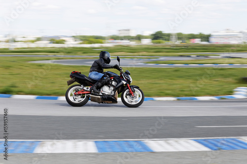 A motorcycle racer makes a practice run on a sports track. Motion blur.