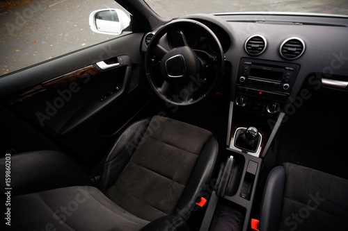 balck luxury car from inside. Close up of steering wheel, seat and circuit