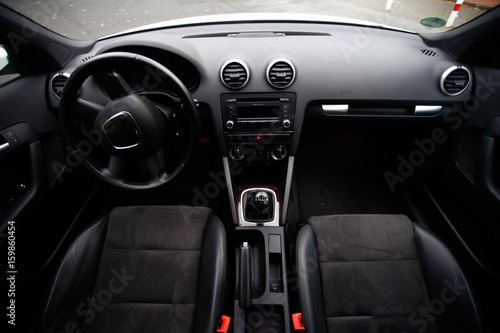 balck luxury car from inside. Close up of steering wheel, seat and circuit © Sylvia