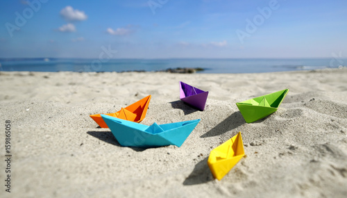 bunte Papierboote im Sand