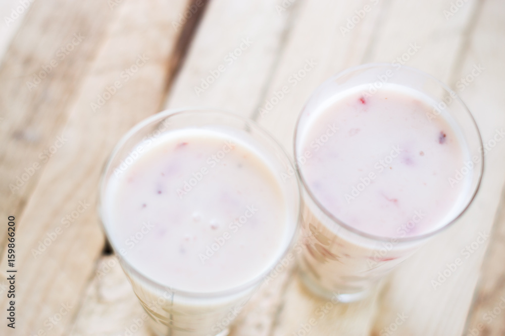Milk shake yogurt with strawberry slices on a wooden background. Milk shake yogurt with strawberry slices on a wooden background.