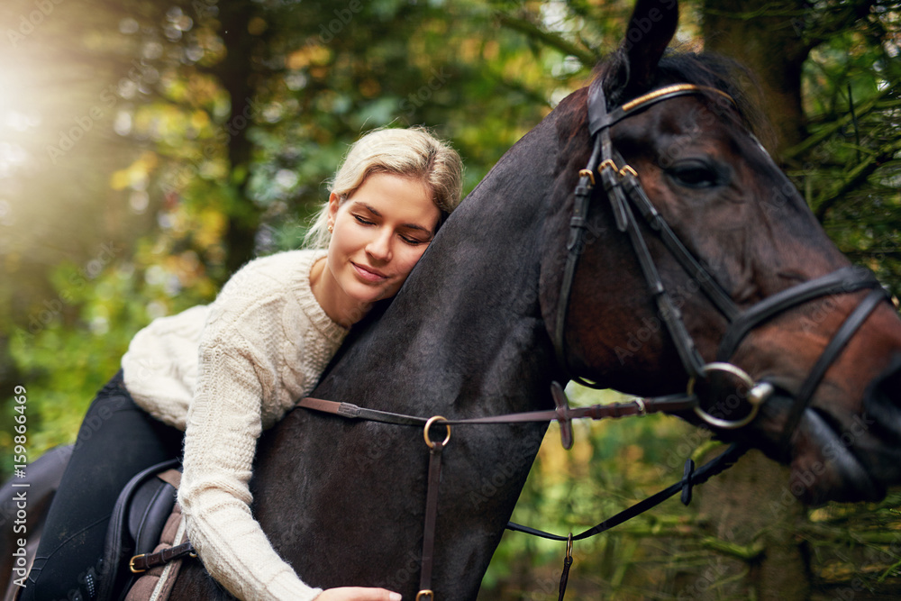 Smiling woman hugging her horse in park Smiling woman hugging her horse in park