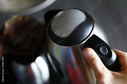 Close up of male hands that prepare a delicious coffee with naturally colors in soft-focus in the background.