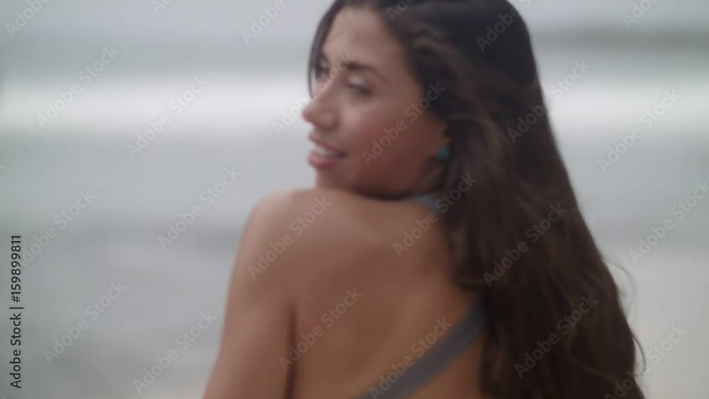 Attractive and happy girl with long hair in the swimsuit resting on the beach Attractive and happy girl with long hair in the swimsuit resting on the beach