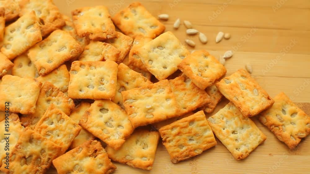 Pile of homemade wholegrain crackers with sunflower seeds on a wooden table Pile of homemade wholegrain crackers with sunflower seeds on a wooden table