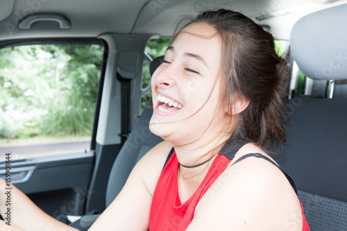 smiling cheerful girl in car drive outdoor © OceanProd