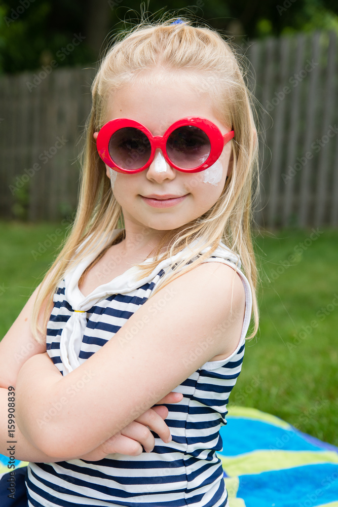 adorable school age girl with sunscreen and sunglasses on outside in summertime adorable school age girl with sunscreen and sunglasses on outside in summertime