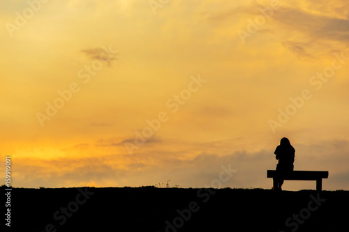 silhouette of woman relax on chair happy time sunset © thechatat