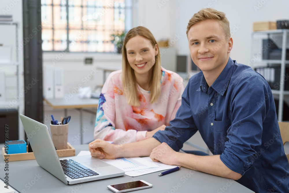 junge mitarbeiter sitzt am schreibtisch im büro junge mitarbeiter sitzt am schreibtisch im büro