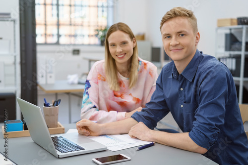 junge mitarbeiter sitzt am schreibtisch im büro