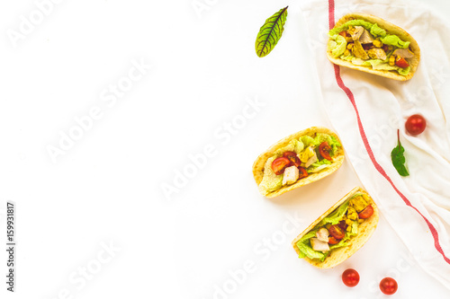 Healthy mexican tacos with vegetables, chicken fillet, tomato, tortillas, salad, corn on white background. Flat lay, top view