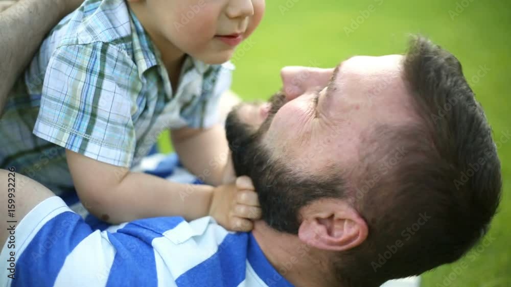 Man lying with his son on the grass in the park and having fun
Man lying with his son on the grass in the park and having fun
