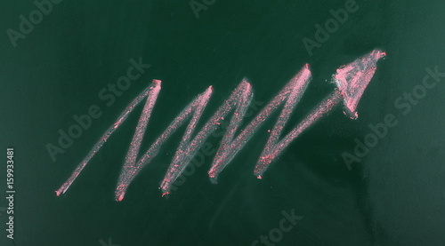 Red zig-zag arrow pointing right on chalkboard, blackboard texture