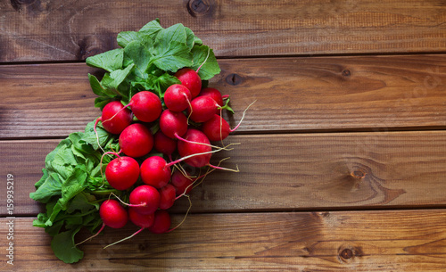 A bunch of radishes on a wooden table with place for text