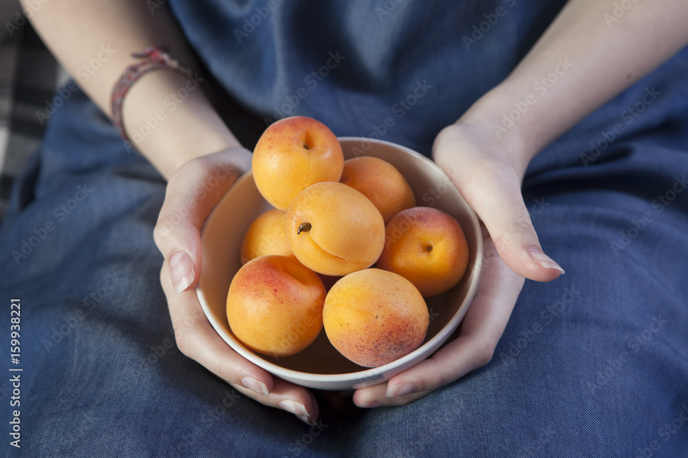 the Woman hands keeping crockery with mellow apricots