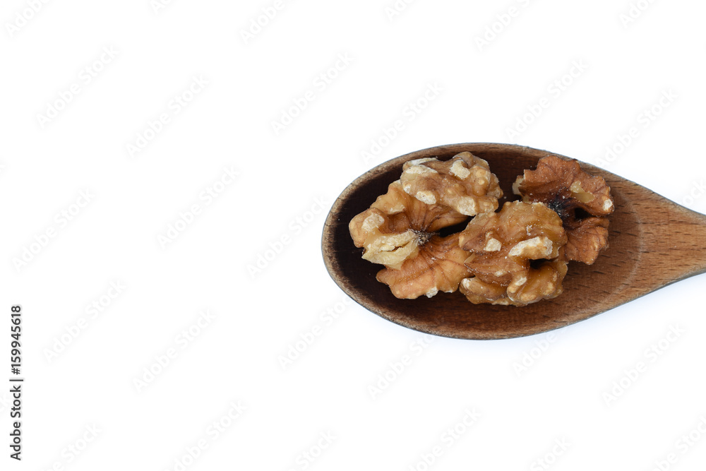 Walnut kernels in wooden spoon isolated on white background. Walnut kernels in wooden spoon isolated on white background.