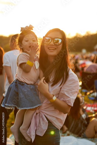 Happy Asain mom and daughter in sunset with sunglasses
