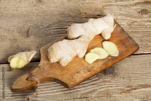 Raw ginger root on wooden background.