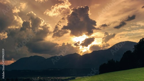 4K. Timelapse of dramatic sunrise in summer with sunrays and flying clouds over Alps in Bad Haering of Austria. Europe. photo