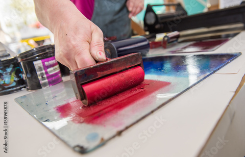 an acrylic paint roller for mono printing and screen printing, rolling paint ready for mono printing.