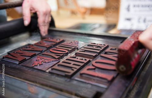 vintage  wooden antique analogue typeset letter blocks being prepared for block printing. photo