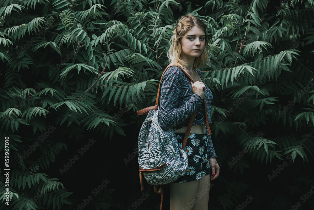 Beautiful autumn woman holding bag against leaves