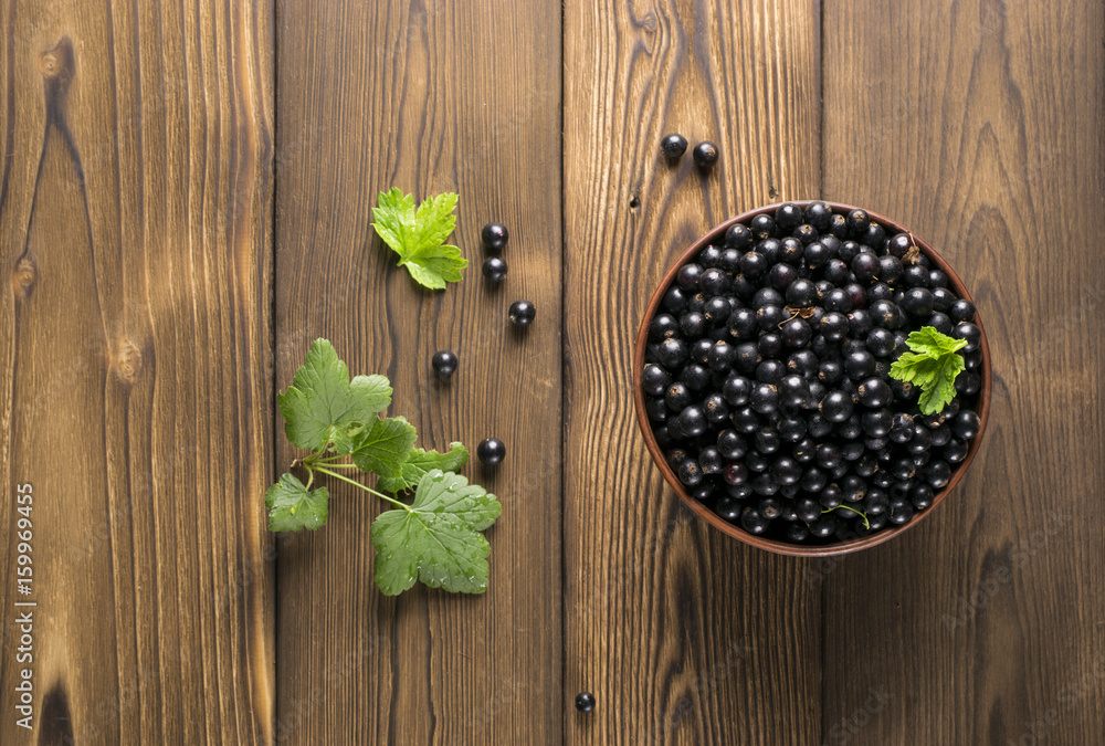 Black currant on wooden table with leaf sprig Black currant on wooden table with leaf sprig