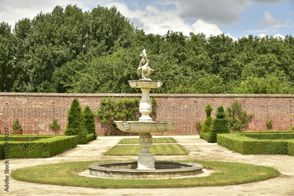 Fontaine rustique au milieu d'un cercle de pelouse au Jardin à la Française au domaine du château de Gaasbeek près de Bruxelles