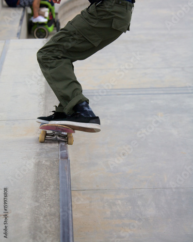 Male doing rail grind while skateboarding at Venice Skate Park in Venice Beach California.