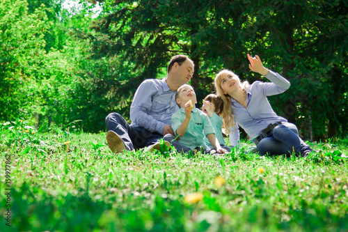 A family of four eat ice cream outdoors. © ferkhova