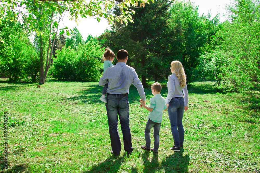 A family of four walks in the park. A family of four walks in the park.