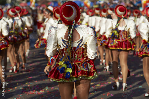 Caporales dance group in ornate red and white costumes performing at the annual Carnaval Andino con la Fuerza del Sol in Arica, Chile.