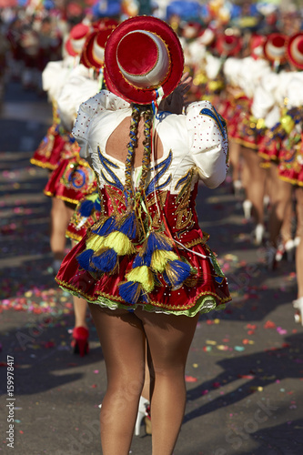 Caporales dance group in ornate red and white costumes performing at the annual Carnaval Andino con la Fuerza del Sol in Arica, Chile.