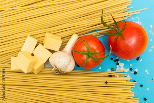 A set of ingredients for cooking pasta on a blue background.