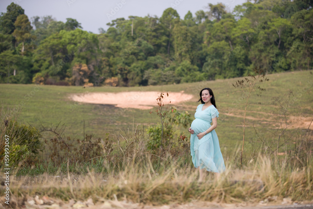 Pregnant Woman Standing in forest Pregnant Woman Standing in forest