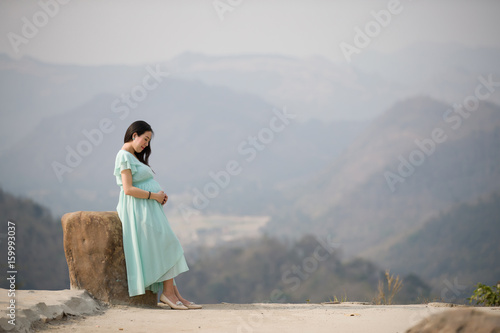 Pregnant Woman Standing on Mountain
