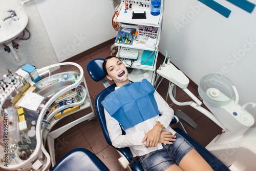 The girl patient with a retractor at the dentist office