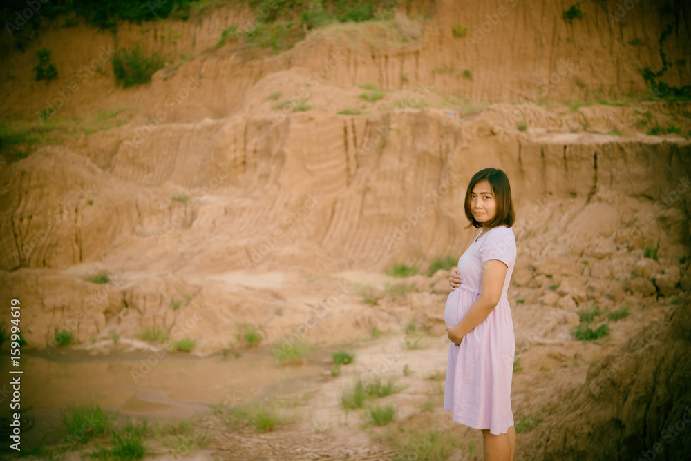 Beautiful pregnant woman stand on the cliff vintage style,film tone,dark,asian girl