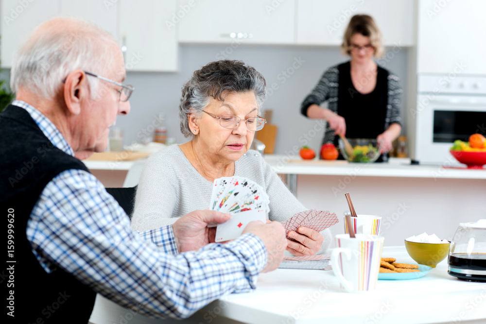 old couple playing cards at home