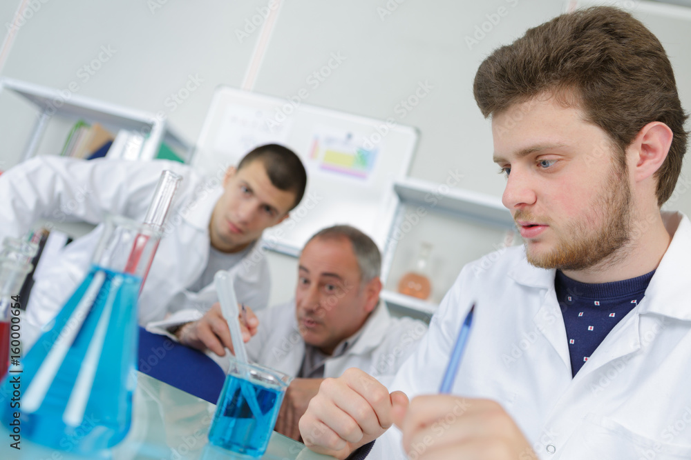 Obraz premium supervisor helping trainee with pippetes