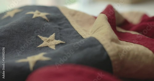American flag detail with red and white stripes with field of blue and circle of 13 stars, the flag designed by Betsy Ross during the American Revolution. Shot in cinematic 4K.