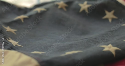 American flag detail with red and white stripes with field of blue and circle of 13 stars, the flag designed by Betsy Ross during the American Revolution. Shot in cinematic 4K.