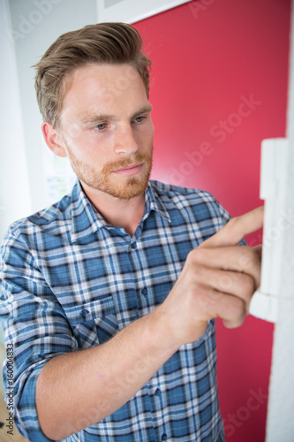 man setting the temperature on control panel
